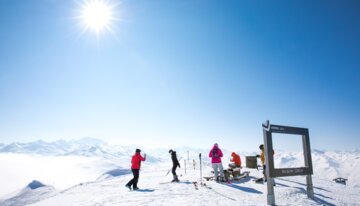 Skieurs admirant la vue depuis un sommet enneigé.