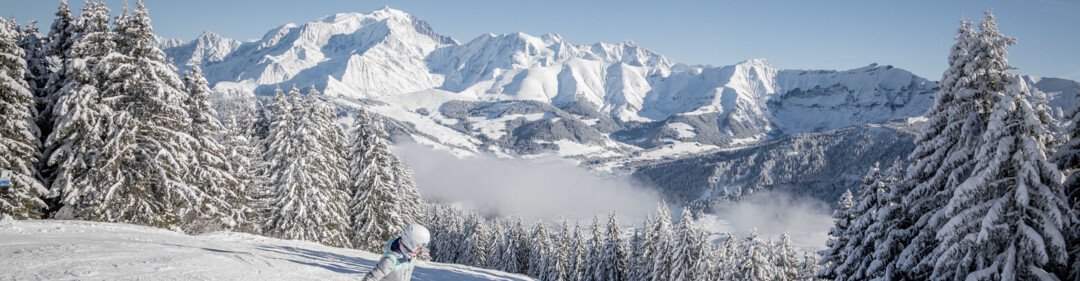 Snowboardeuse sur piste enneigée avec vue sur les montagnes | © Simon Garnier