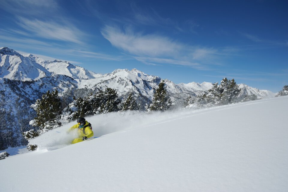 Skier in powder snow with mountain background. | © OT Saint Lary