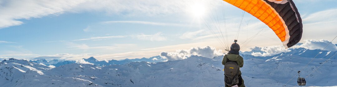 Parapentiste sur un sommet enneigé | © Vincent LOTTENBERG