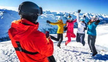 Mann fotografiert springende Skifahrerinnen im Schnee. | © Vincent LOTTENBERG