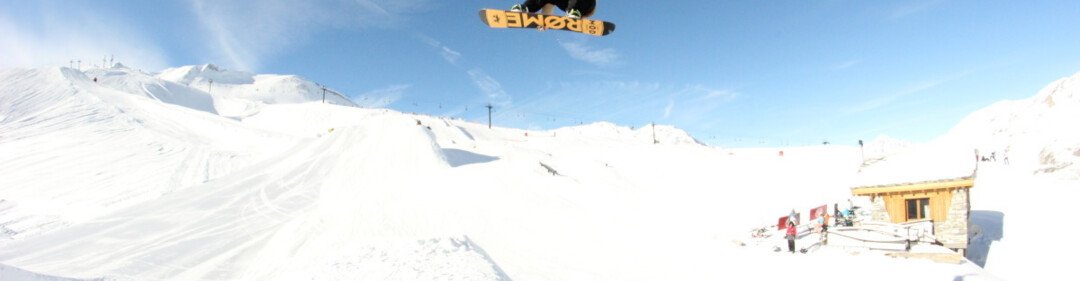 Snowboarder springt über eine Schneeschanze in den Himmel. | © Val d'Isère Tourisme | Julien Lecointe