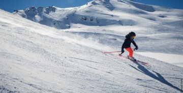 Skifahrer auf schneebedecktem Hang vor Bergkulisse. | © Val d'Isère Tourisme | Richard Bord