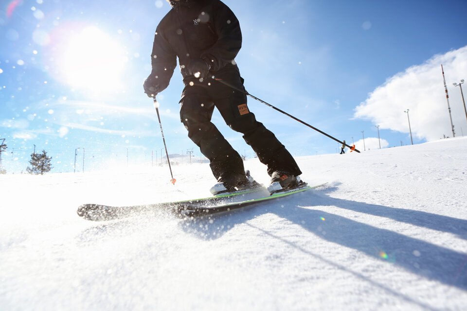 Skifahrer auf schneebedeckter Piste bei Sonnenschein. | © Elina Sirparanta | Visit Finnland
