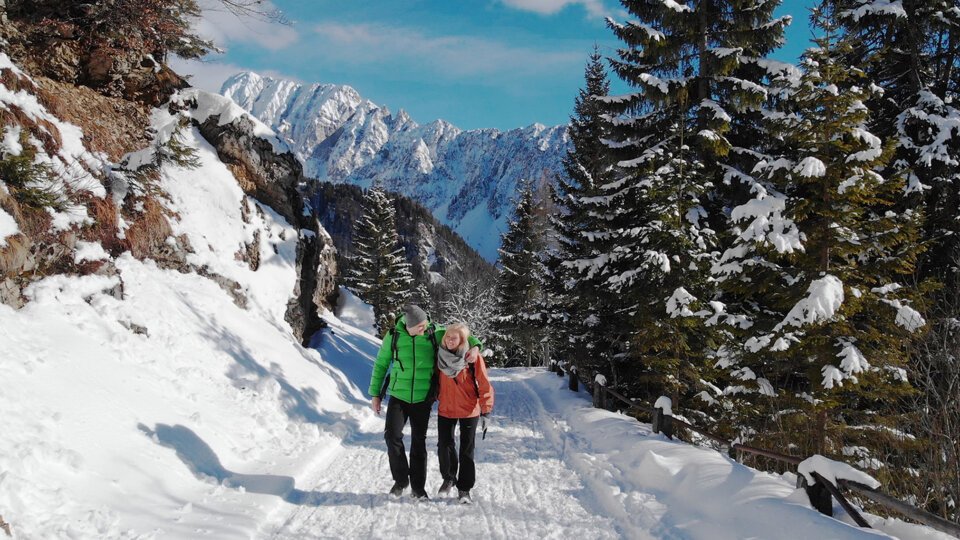 Ein Paar wandert im Schnee vor einer Bergkulisse. | © Andrej Virc | www.slovenia.info