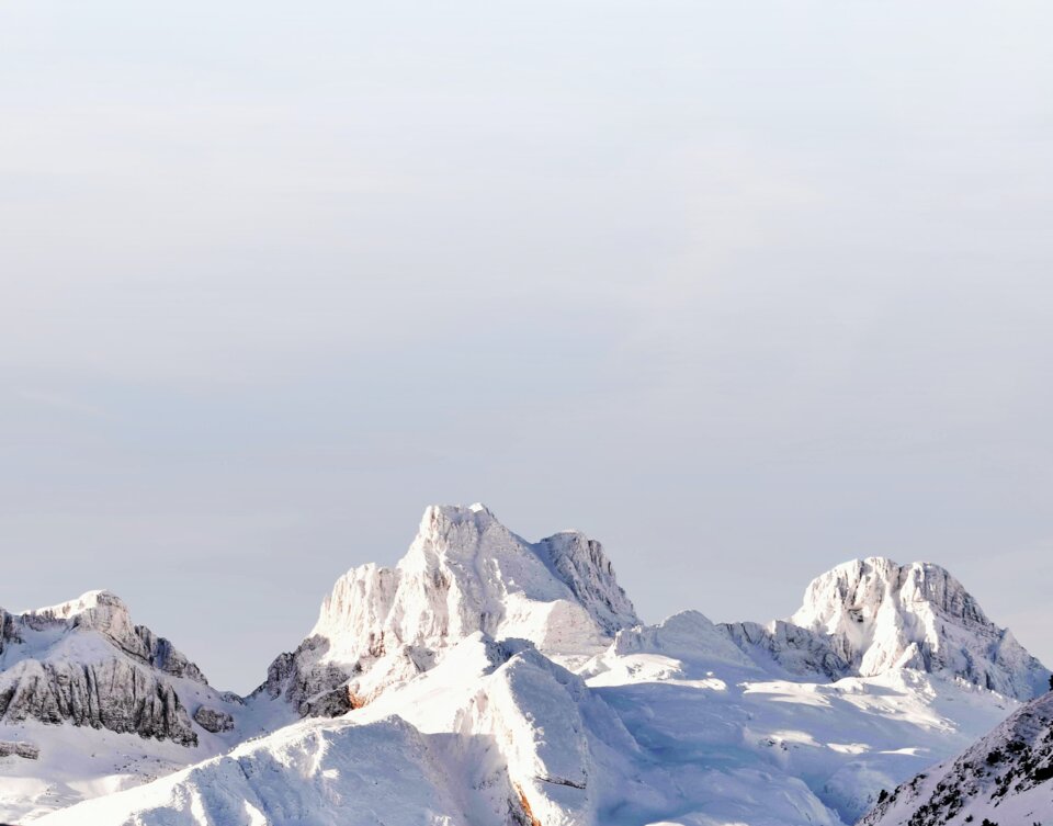 Snow-covered mountain peaks under a bright sky