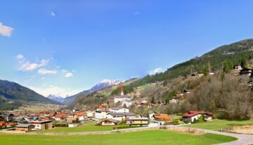 Vue panoramique d'un village alpin et montagnes. | © www.wikipedia.com