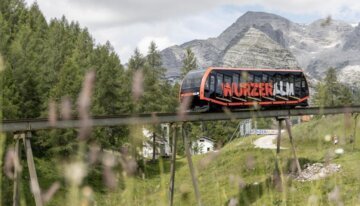 Wurzeralm monorail on elevated track with mountain backdrop | ©  © HIWU Hinterramskogler