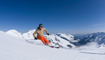 Skifahrer auf schneebedecktem Hang vor Bergpanorama. | © ©Tirol Werbung / Ritschel Bernd