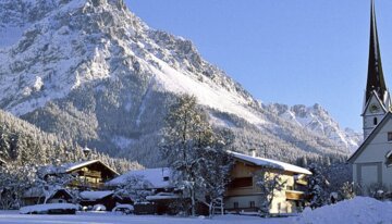 Snowy landscape with mountains, village, and church. | © Tourismusverband Wilder Kaiser