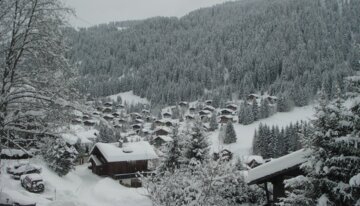 Village de montagne enneigé avec forêt de pins en hiver. | © https://www.flickr.com/photos/20979847@N05/