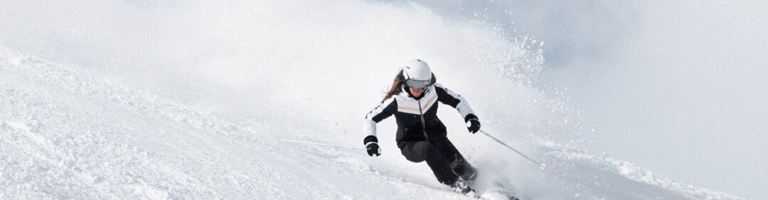 Skifahrerin auf einer schneebedeckten Piste.