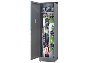 Skischrank mit geöffneter Tür, gefüllt mit Ski, Snowboard und Helmen.