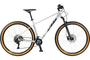 Un VTT semi-rigide KTM blanc avec des pneus à flancs beiges.