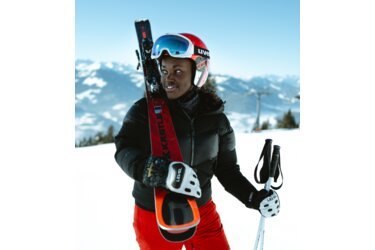 Skifahrerin mit Skiern und Stöcken im Schnee.