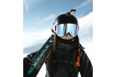 Skieuse avec skis, casque et lunettes dans la neige