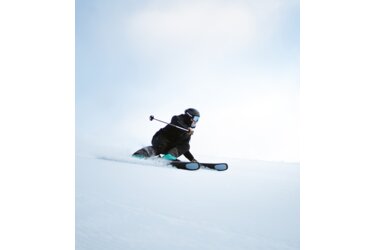 Skier carving down a snowy slope