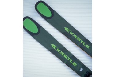 Two green Kästle skis on a snow-covered surface.