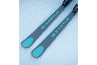 Ein Paar graue Ski mit türkisfarbenen Akzenten liegen im Schnee.