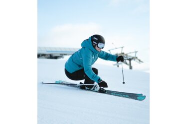 Skifahrerin fährt auf einer schneebedeckten Piste.