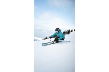 Skifahrerin auf einer Skipiste.