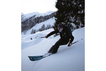 Skieur dévalant une pente enneigée.