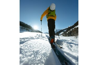 Skier walking uphill in snow.