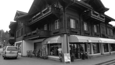 Black and white photo of a multi-story building with a storefront.