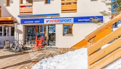 Intersport shop with ski equipment and snowmobile in front.