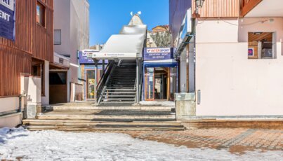 Blick auf eine Treppe zwischen zwei Geschäften im Schnee.