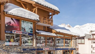 Intersport-Geschäft in einem Skiort mit Schnee auf den Dächern