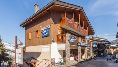 Gebäude mit Skiverleihschildern im Skiort