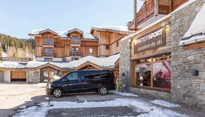Black van parked outside Intersport ski rental shop in the mountains