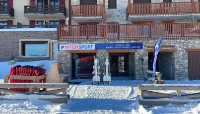 Magasin Intersport dans une station de ski enneigée.