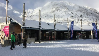 Ski resort with snow-covered mountains and shops.