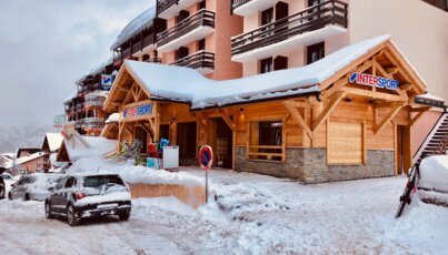 Snowy Intersport store in the mountains with a car.