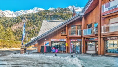Building with an Intersport store in a mountainous region.
