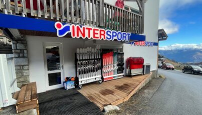 Magasin Intersport avec des skis et des montagnes en arrière-plan