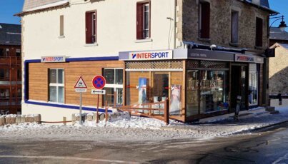 Magasin Intersport dans une ville enneigée.