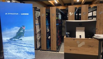 Dynastar x Lange promotional banner and ski display in store.