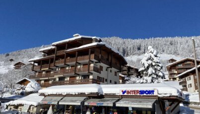 Paysage hivernal avec magasin Intersport et montagnes enneigées