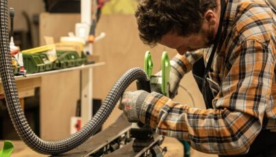 Man working on skis in workshop.