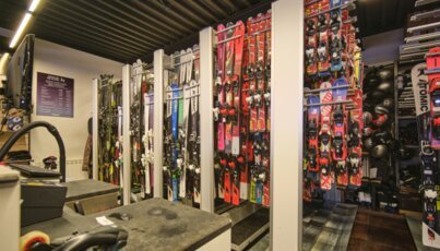 Skiverleihgeschäft mit Skiern und Helmen.