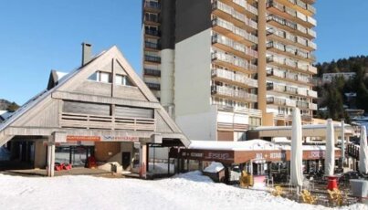 Bâtiment dans la neige avec hôtel en arrière-plan