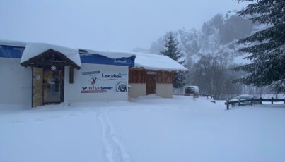 Snow-covered hut with Intersport sign in winter