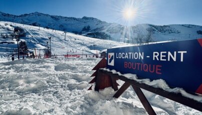 Panneau indiquant 'Location - Rent Boutique' dans la neige.