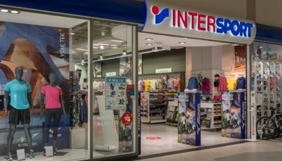 Eingang zu einem Intersport-Geschäft mit Schaufensterpuppen und Mizuno-Werbung