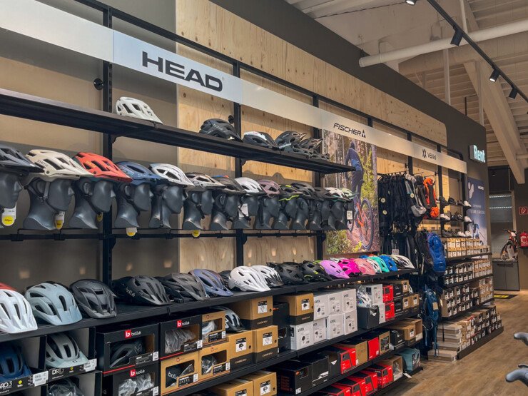 Shelves of bicycle helmets and accessories in a store.