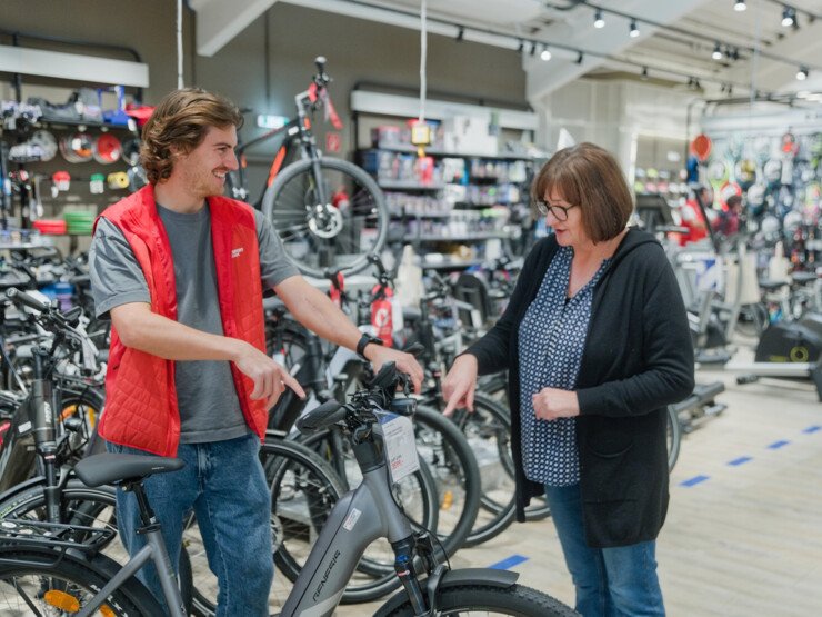 Un employé montre un vélo électrique à une dame